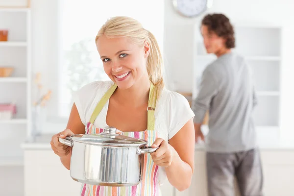 Frau posiert mit einem Boiler, während ihr Verlobter die Wäsche wäscht — Stockfoto