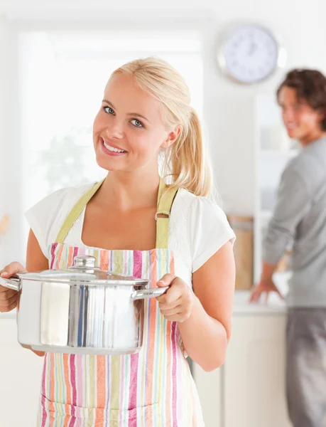 Портрет женщины, позирующей, пока ее жених моет посуду — стоковое фото