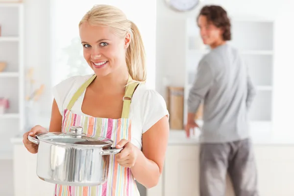 Retrato de uma mulher posando enquanto um homem está lavando os pratos — Fotografia de Stock