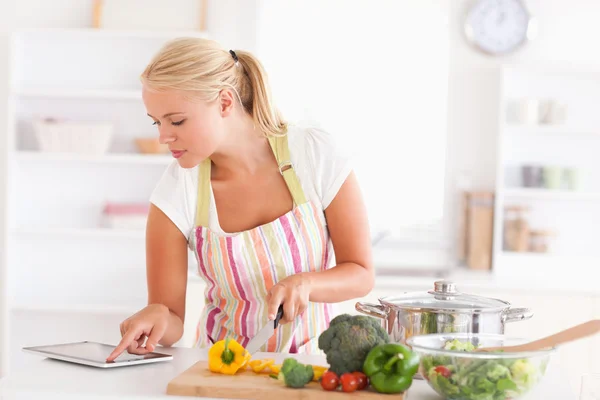 Mujer rubia usando una tableta para cocinar —  Fotos de Stock