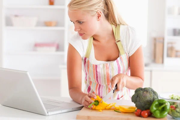 Close up de uma mulher usando um laptop para cozinhar — Fotografia de Stock