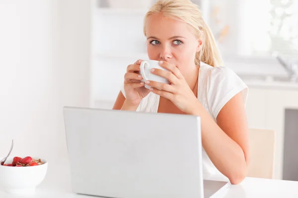 在使用她的笔记本电脑时喝茶的女人 — 图库照片