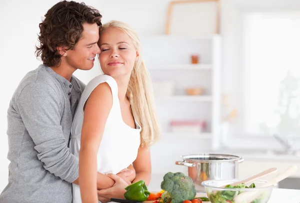 Linda pareja abrazándose mientras cocina — Foto de Stock