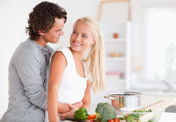 Bella coppia che si abbraccia mentre cucina — Foto Stock