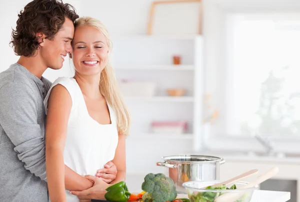 Beautiful couple hugging while cooking — Stock Photo, Image