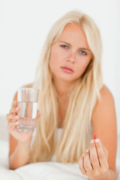 Retrato de una mujer enferma tomando una pastilla — Foto de Stock