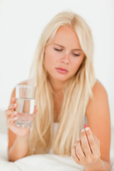 Portrait of an ill woman taking a pill — Stock Photo, Image