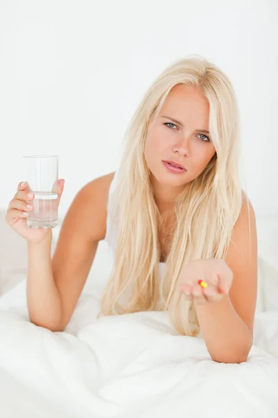 Portrait of a woman showing a pill — Stock Photo, Image