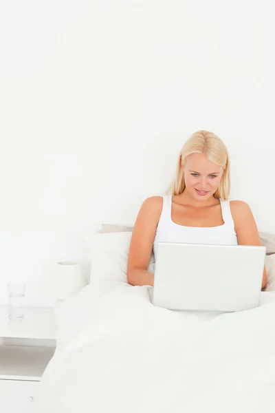 Gülümseyen kadın bir dizüstü bilgisayar kullanarak — Stok fotoğraf
