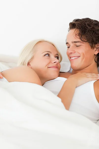 Porträt eines Paares, das auf einem Bett liegt und sich umarmt — Stockfoto
