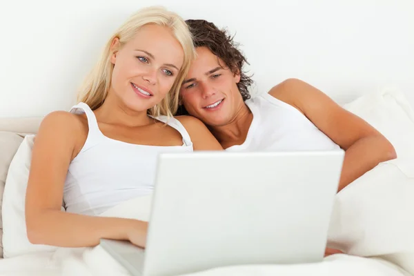 Paar lettend op een film met een laptop — Stockfoto