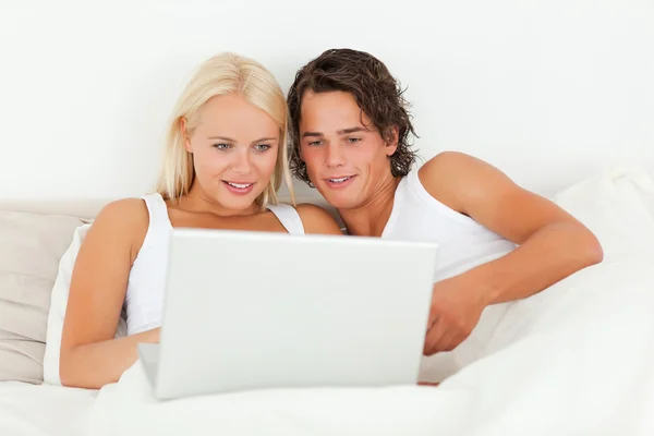 Νεαρό ζευγάρι, βλέποντας μια ταινία με ένα φορητό υπολογιστή — Φωτογραφία Αρχείου
