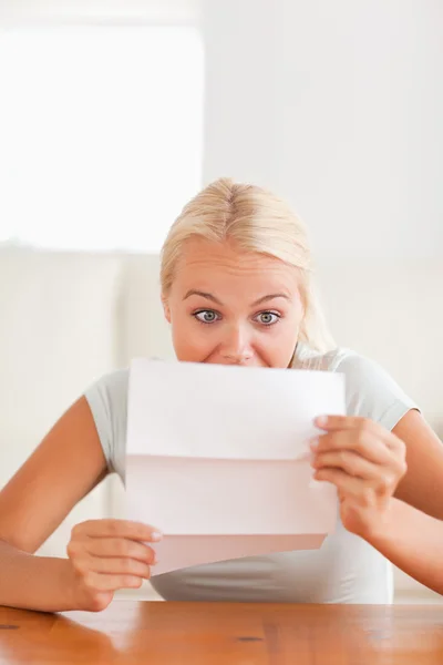 Woman looking at a letter in disbelief — Stock Photo, Image