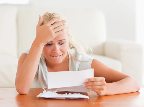 Blond woman in despair holding a letter — Stock Photo, Image
