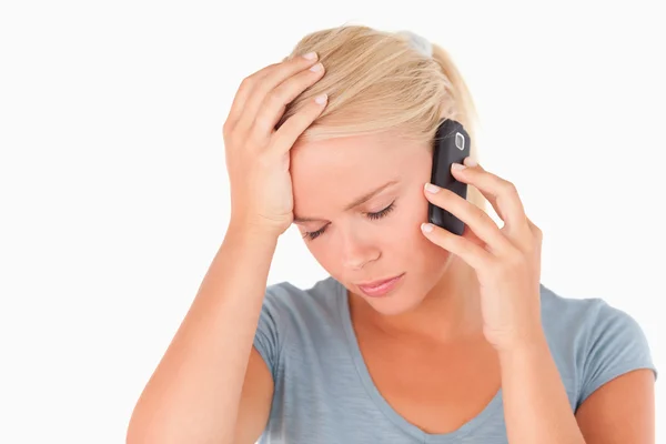 Ledsen blond kvinna på en telefon — Stockfoto