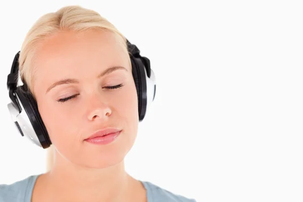 Retrato de uma mulher com fones de ouvido com os olhos fechados — Fotografia de Stock