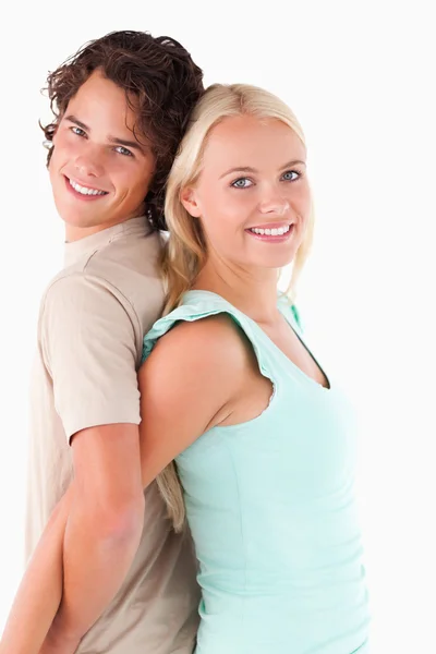 Primer plano de una feliz pareja de pie espalda con espalda —  Fotos de Stock