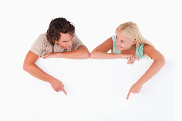 Knappe man en woman wijzend op een whiteboard — Stockfoto