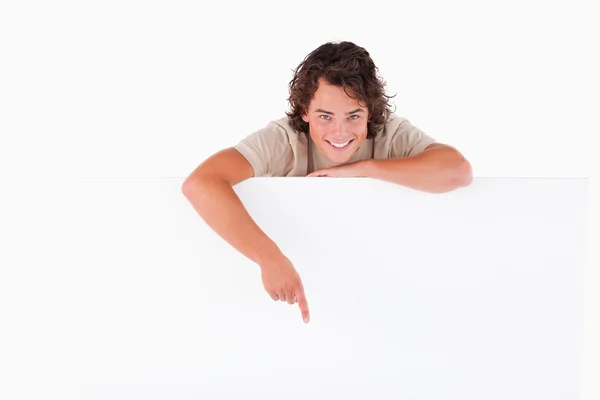 Homem sorridente apontando para um quadro branco — Fotografia de Stock