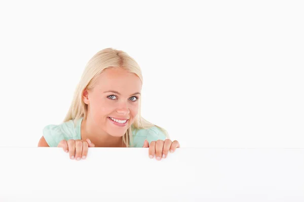 Femme souriante debout derrière un tableau blanc — Photo