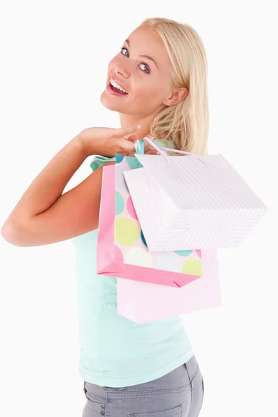 Vrolijke blonde vrouw met shopping tassen — Stockfoto