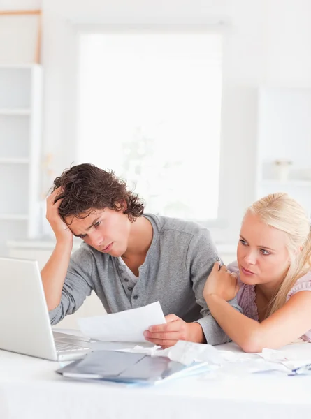 Unhappy couple doing paperwork — Stock Photo, Image