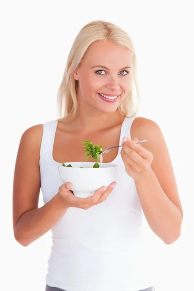 Улыбающаяся леди ест салат — стоковое фото