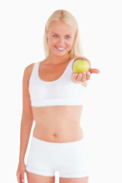 Charmante blonde Frau hält einen Apfel in der Hand — Stockfoto