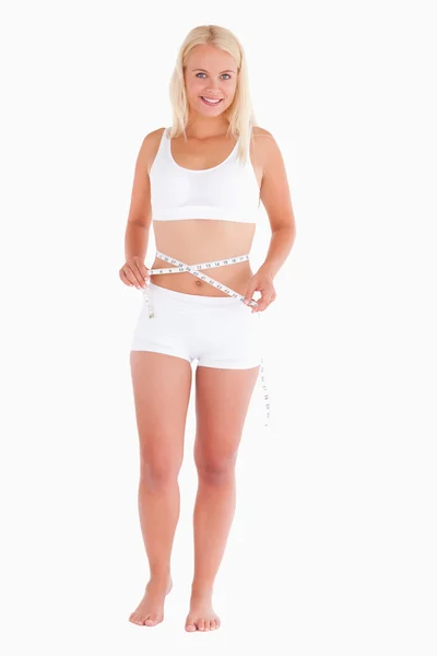 若いブロンドの女性彼女の腰の測定 — ストック写真