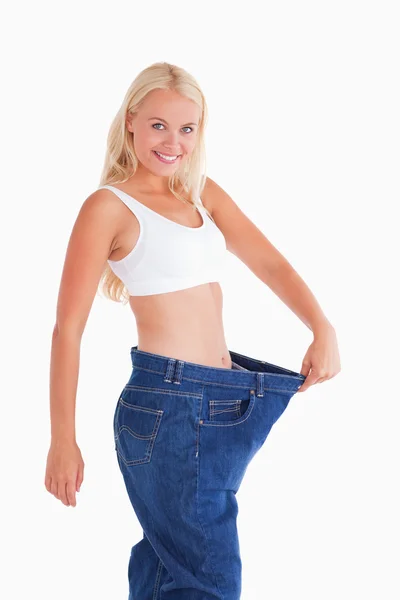 Niedliche Frau trägt zu große Jeans — Stockfoto
