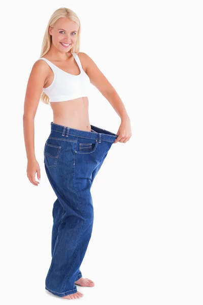 大きすぎるのジーンズを着て魅力的な女性 — ストック写真