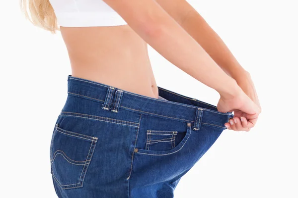 Woman wearing to big jeans — Stock Photo, Image