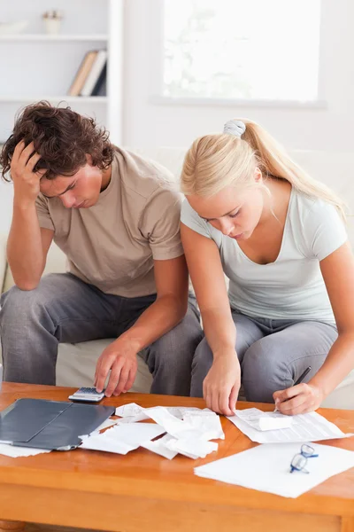 Despaired couple calculating their expenses — Stock Photo, Image