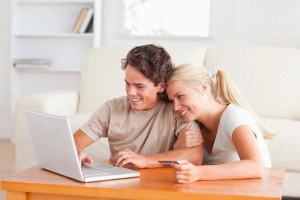 Χαριτωμένο ζευγάρι με ένα φορητό υπολογιστή και μια πιστωτική κάρτα — Φωτογραφία Αρχείου