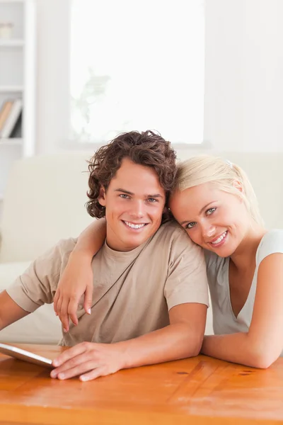 Close up de um abraço bonito casal com um tablet — Fotografia de Stock