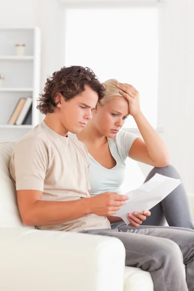 Unhappy couple reading letters — Stock Photo, Image