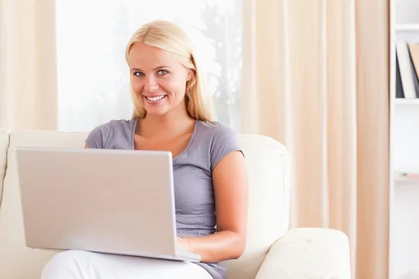 Leende kvinna som använder en bärbar dator — Stockfoto