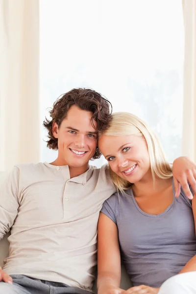 Portret uśmiechający się para siedzi na kanapie — Zdjęcie stockowe