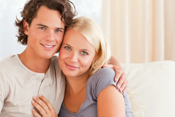 Lovely couple sitting on a couch — Stock Photo, Image