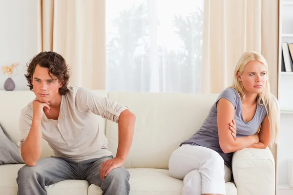 Addolorata coppia seduta su un divano — Foto Stock