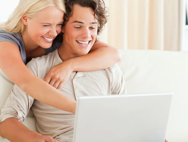 Casal rindo usando um laptop — Fotografia de Stock