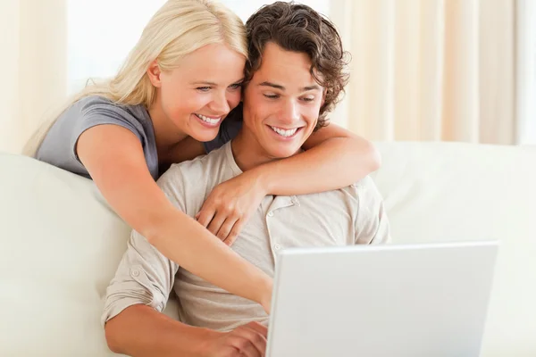 Leende par använder en bärbar dator — Stockfoto