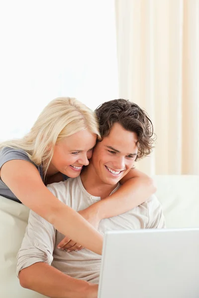 Porträtt av ett leende par som använder en bärbar dator — Stockfoto