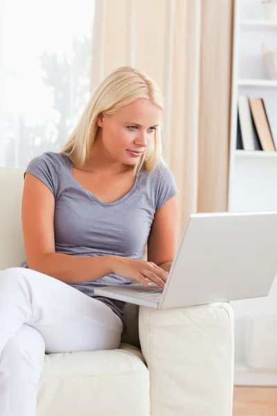 Portret van een glimlachende blonde vrouw die een laptop gebruiken — Stockfoto