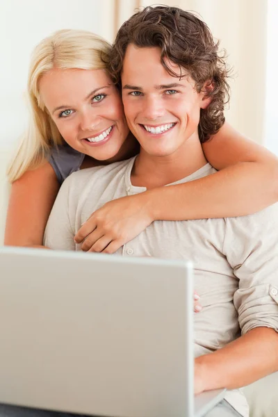 Porträtt av ett lyckligt par med en bärbar dator — Stockfoto