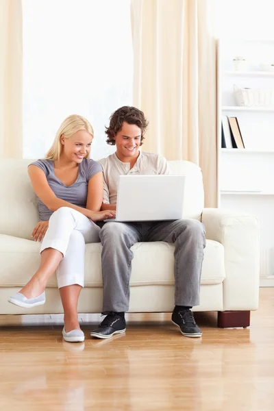 Portrait of an in love couple using a laptop — Stock Photo, Image