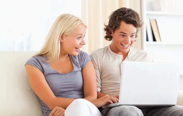 Surprised couple using a laptop — Stock Photo, Image