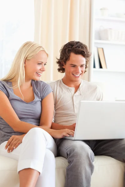 Porträtt av en söt lyckliga par som använder en bärbar dator — Stockfoto