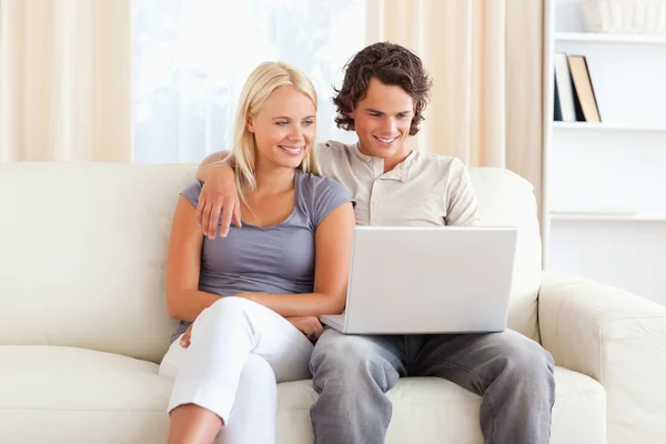 Casal amigável usando um laptop — Fotografia de Stock