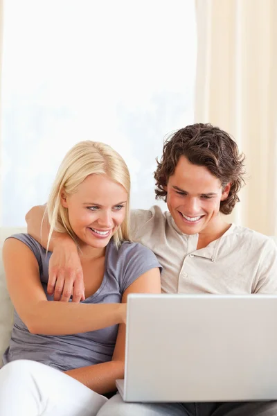 Retrato de una joven pareja sonriente usando un portátil — Foto de Stock